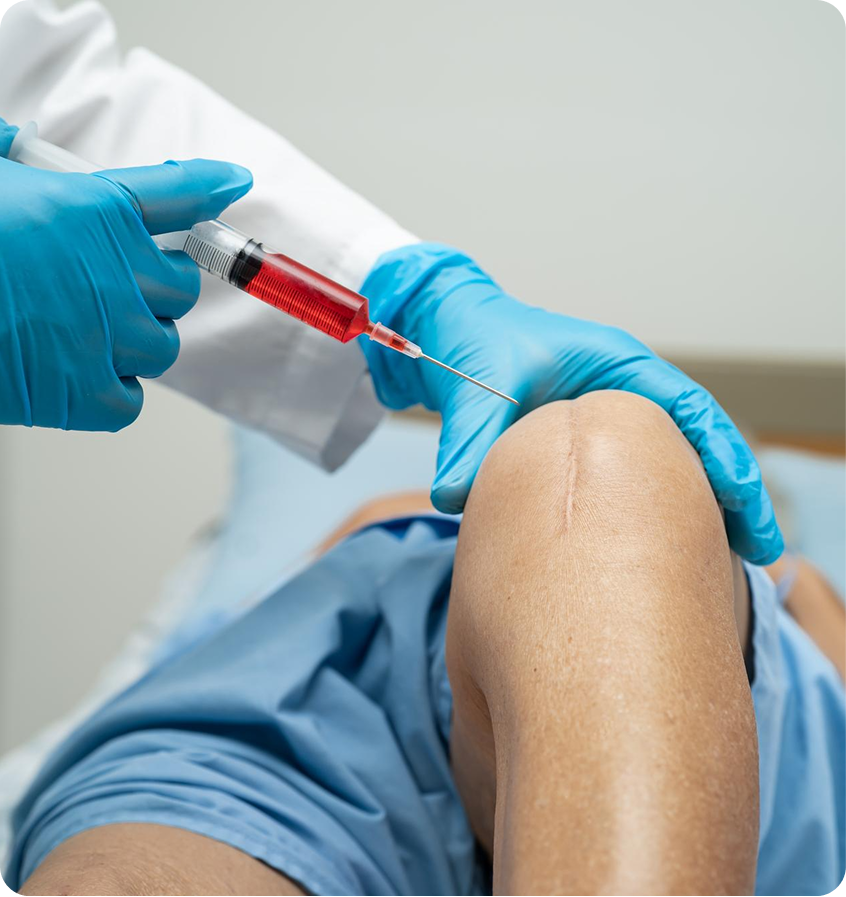 Gloved clinician preparing an injection near a patient’s knee
