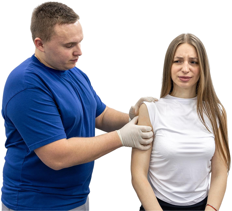 Clinician examining a seated woman’s upper arm and shoulder