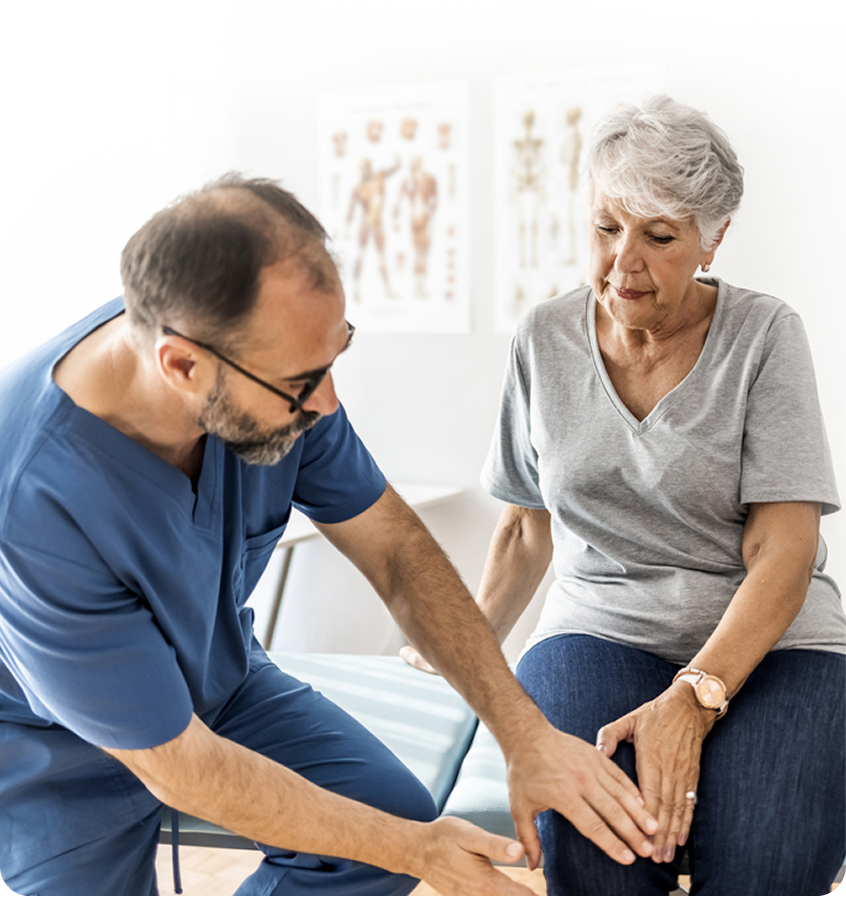 Clinician examining an older woman’s knee