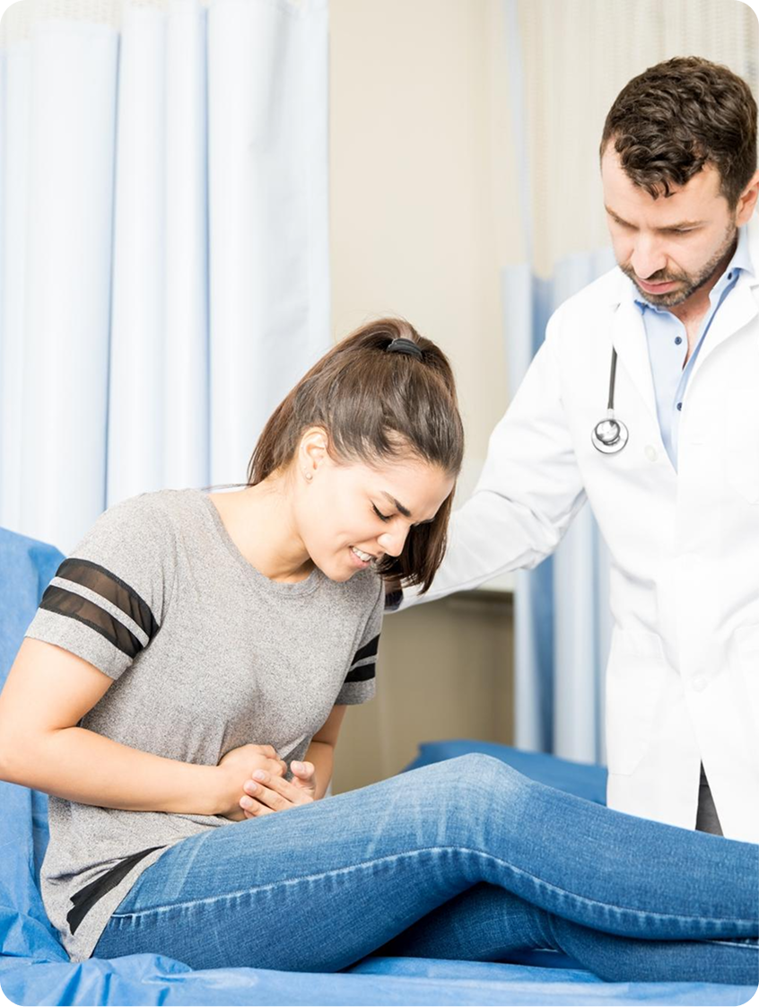 Physician supporting a seated woman experiencing abdominal pain