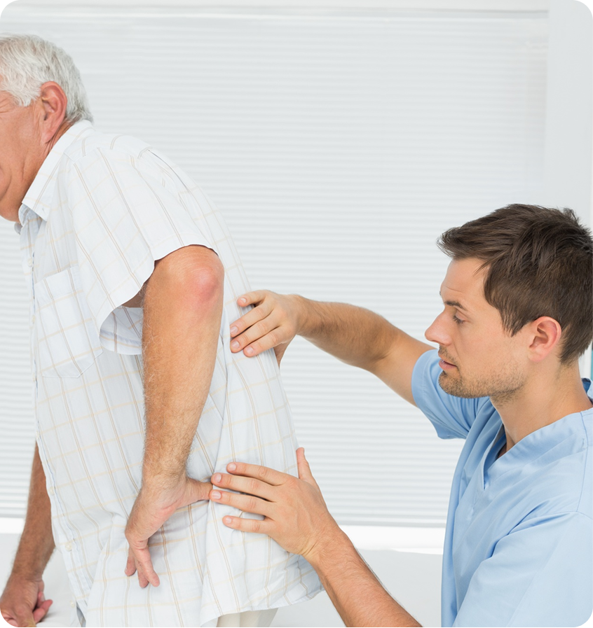 Clinician examining an older man’s lower back