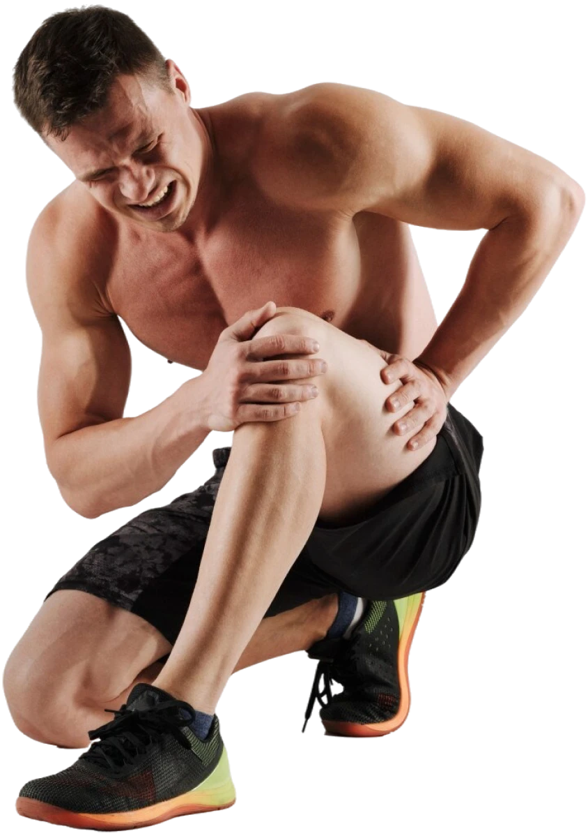 Athletic man crouching and gripping a painful knee