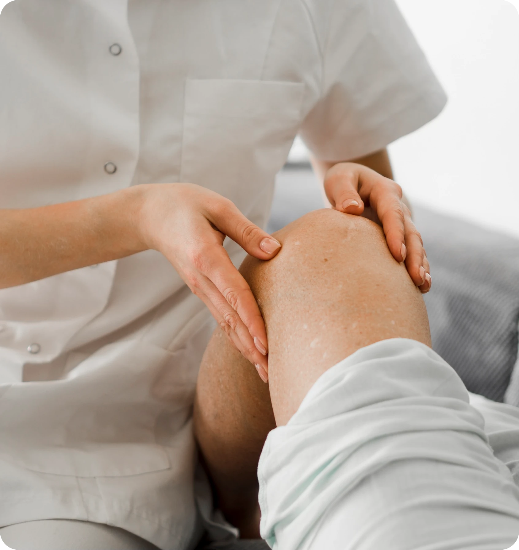 Clinician examining a patient’s bent knee with both hands