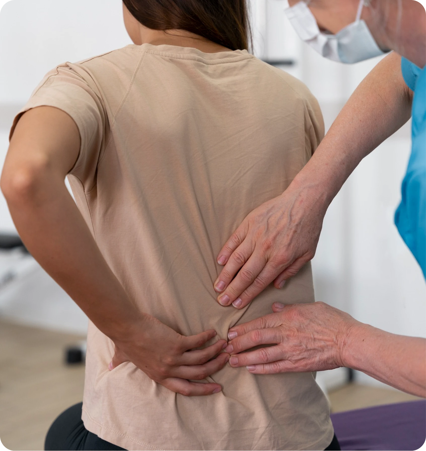 Clinician examining a woman’s lower back