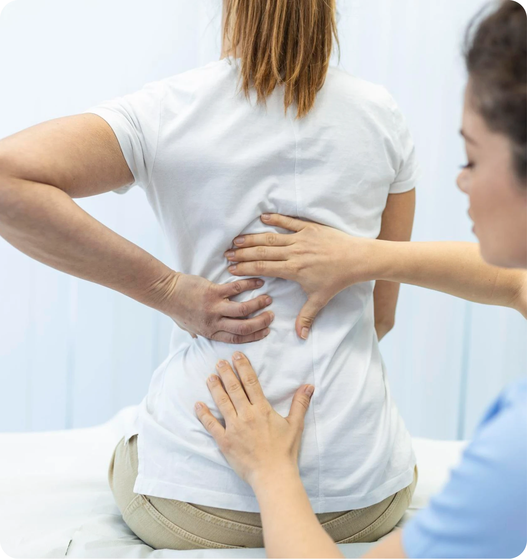 Clinician assessing a seated patient’s lower back